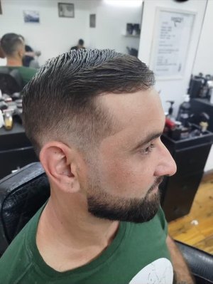 Cliente de perfil com barba grisalha alinhada