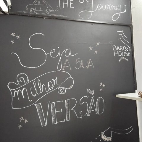 Quadro-negro da barbearia com a frase Seja a sua melhor versão escrita à mão em giz